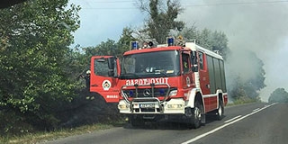 Lángra kapott az út menti bozótos Versend mellett